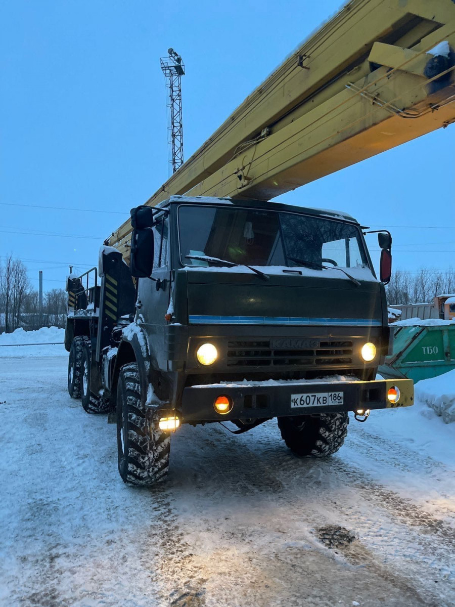 Разгрузка машины автокраном со стропальщиками